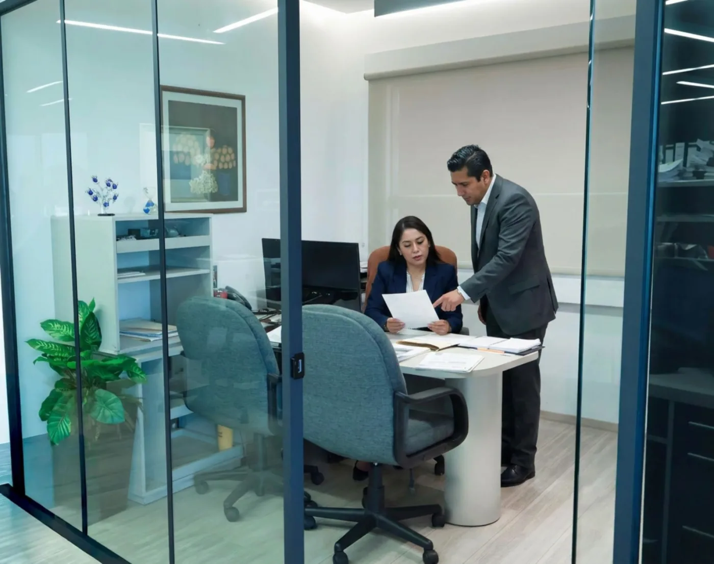 Dos integrantes del despacho revisando estados financieros en una oficina de J.W.K. Business